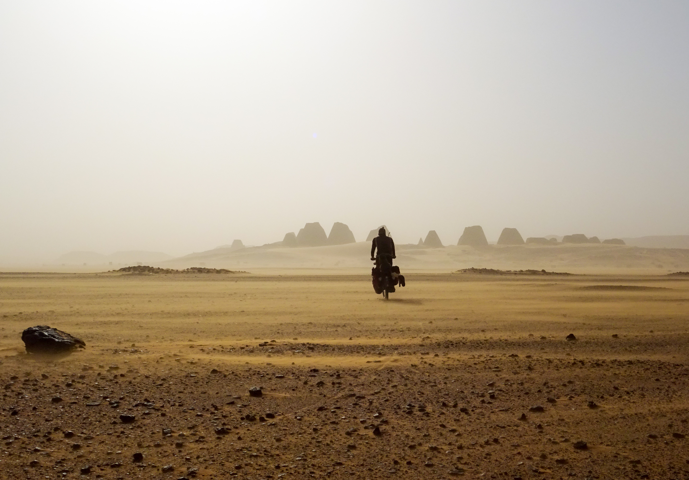 Zeigt einen Fahrradfahrer in der Wüste